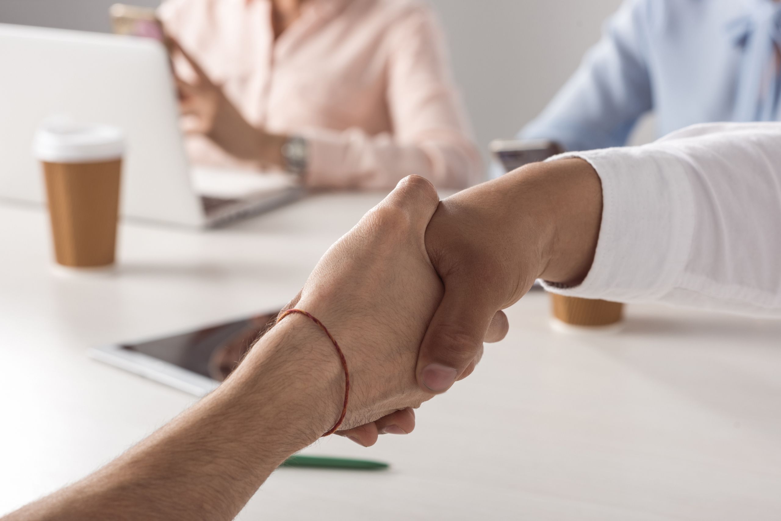 cropped shot of business colleagues shaking hands at meeting